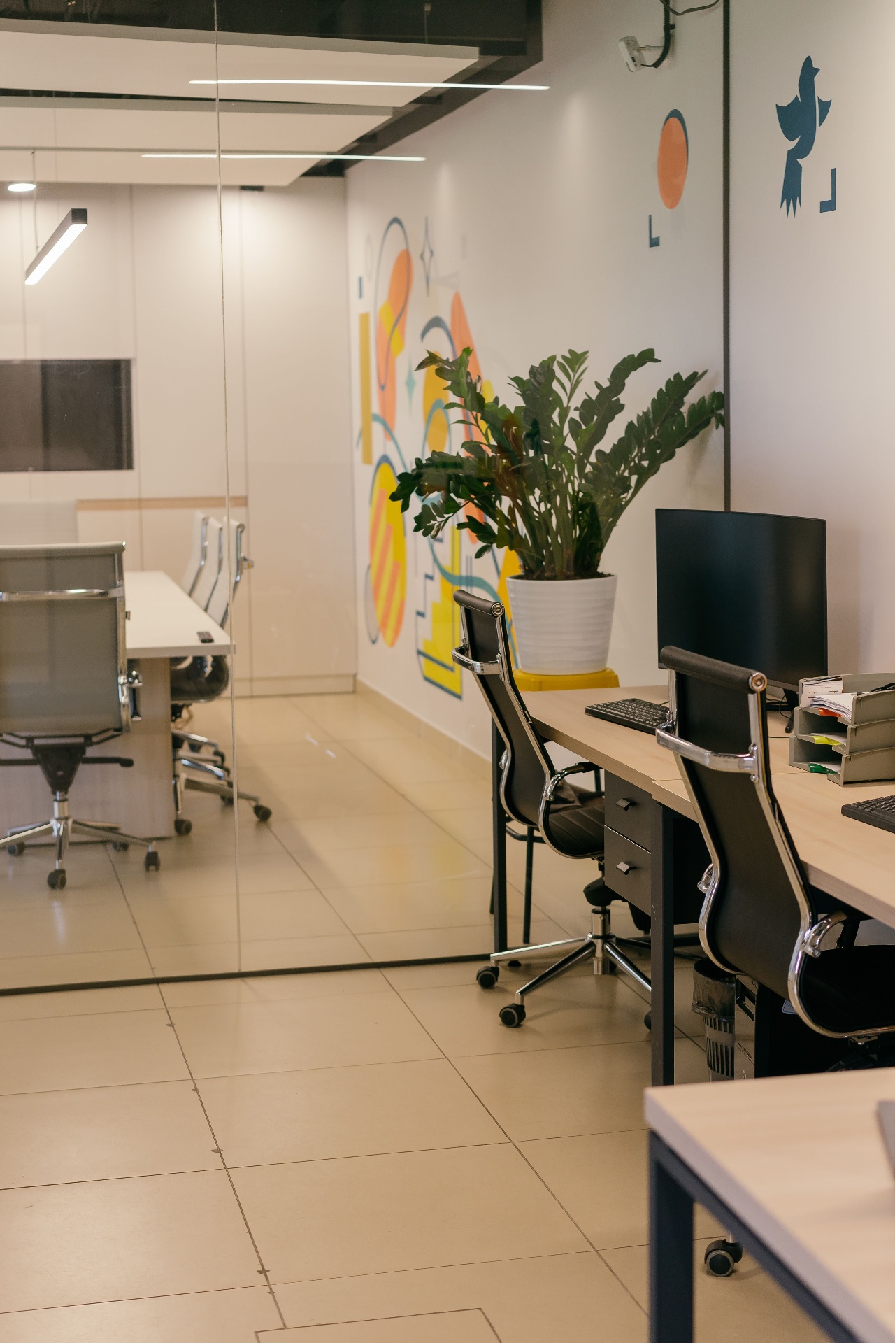 A bright contemporary office with desks, computers and colourful Caribbean-inspired artwork